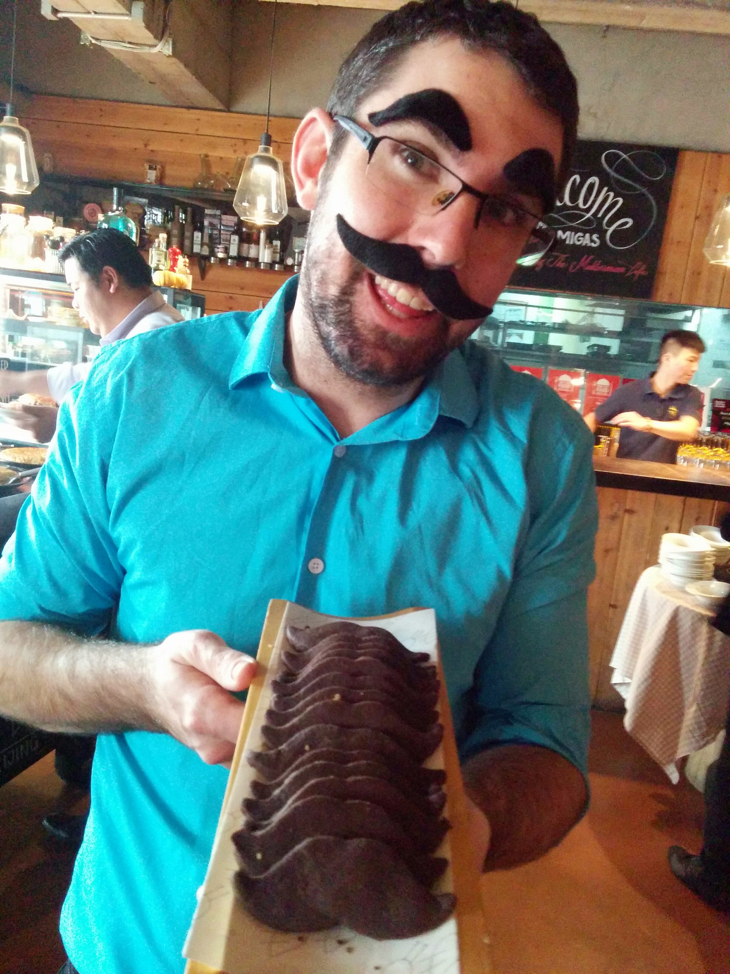 CD Maovember 2015 Juan Matas with mustache-shaped cookies at the Migas Maovember El Asador Brunch.